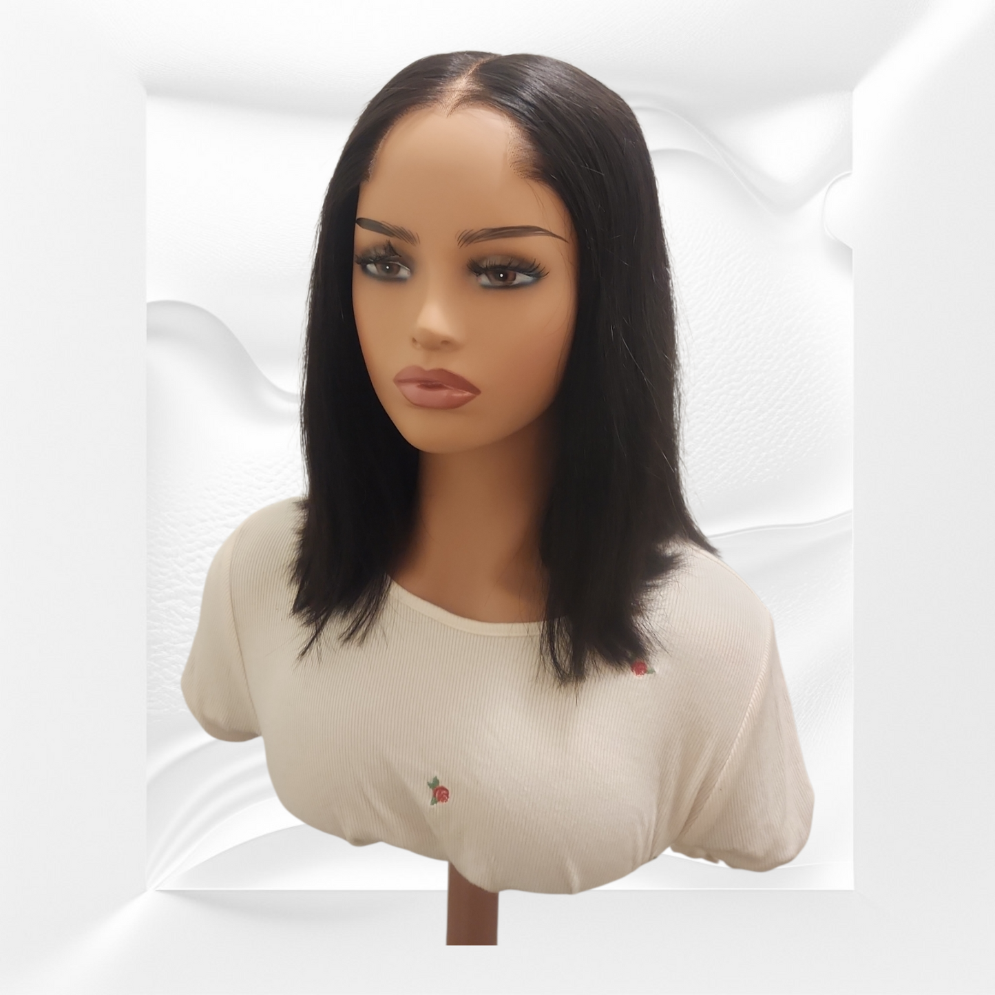 Mannequin head with a black wig on a white background