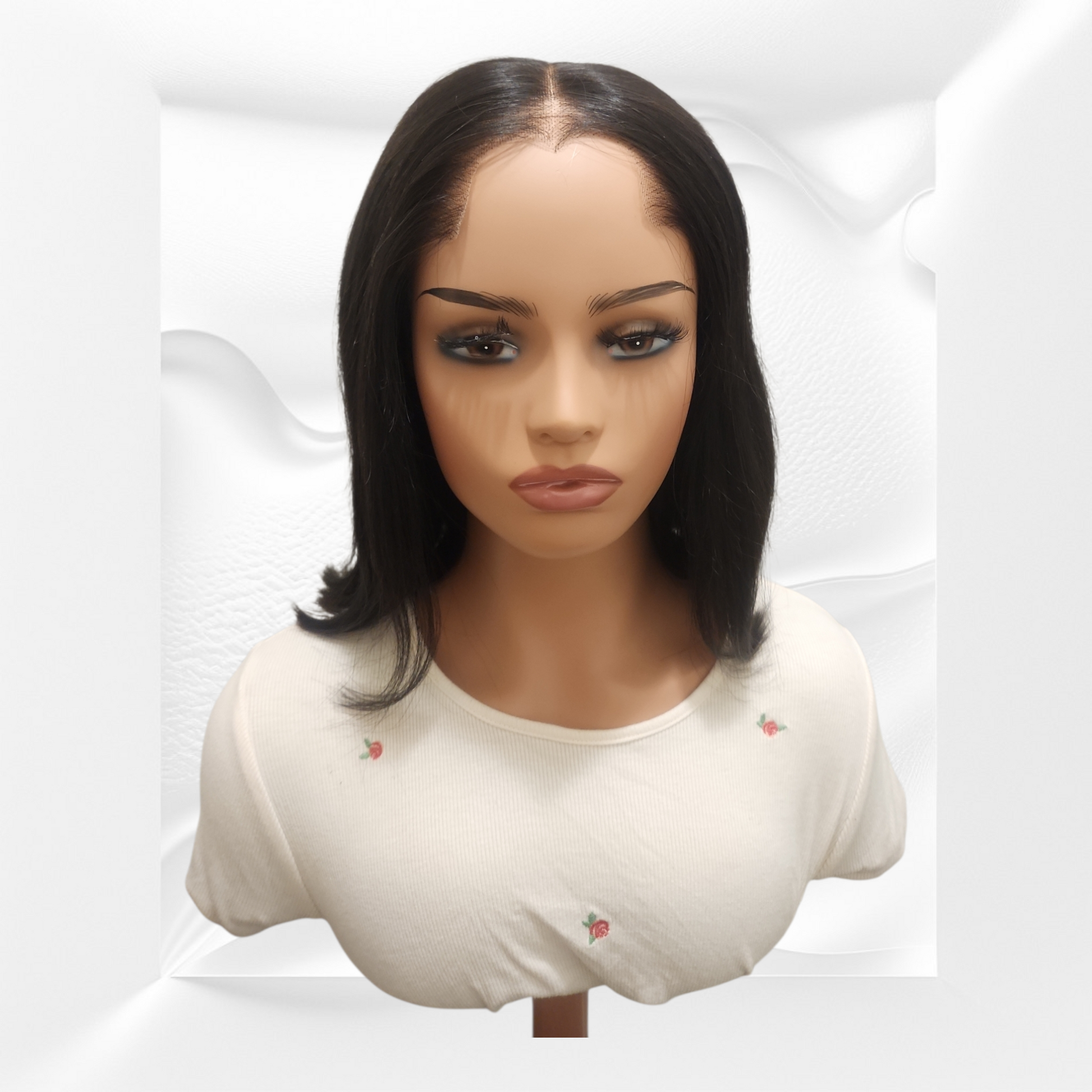 Mannequin head with a black wig on a white background