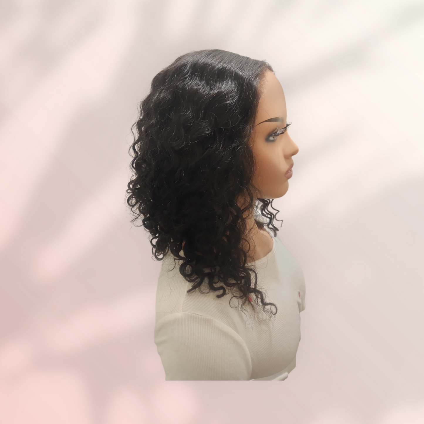 Mannequin head with a wig on a plain background