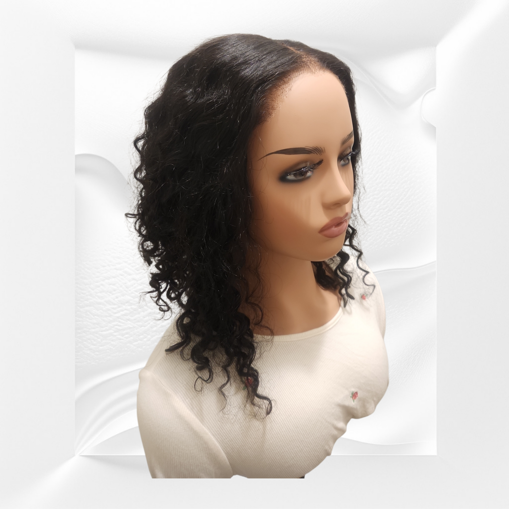 Mannequin head with a black curly wig on a white background