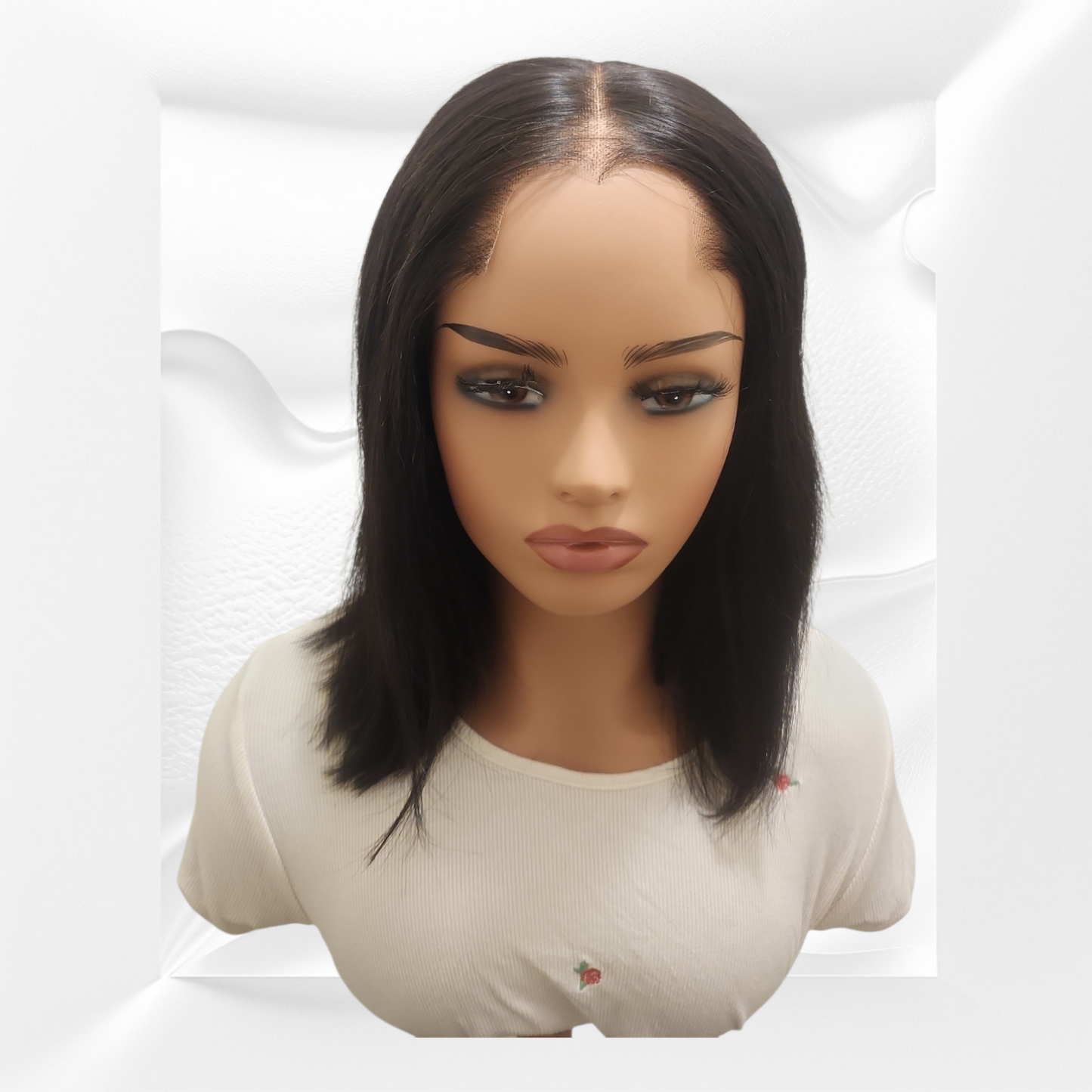 Mannequin head with a black wig on a white background