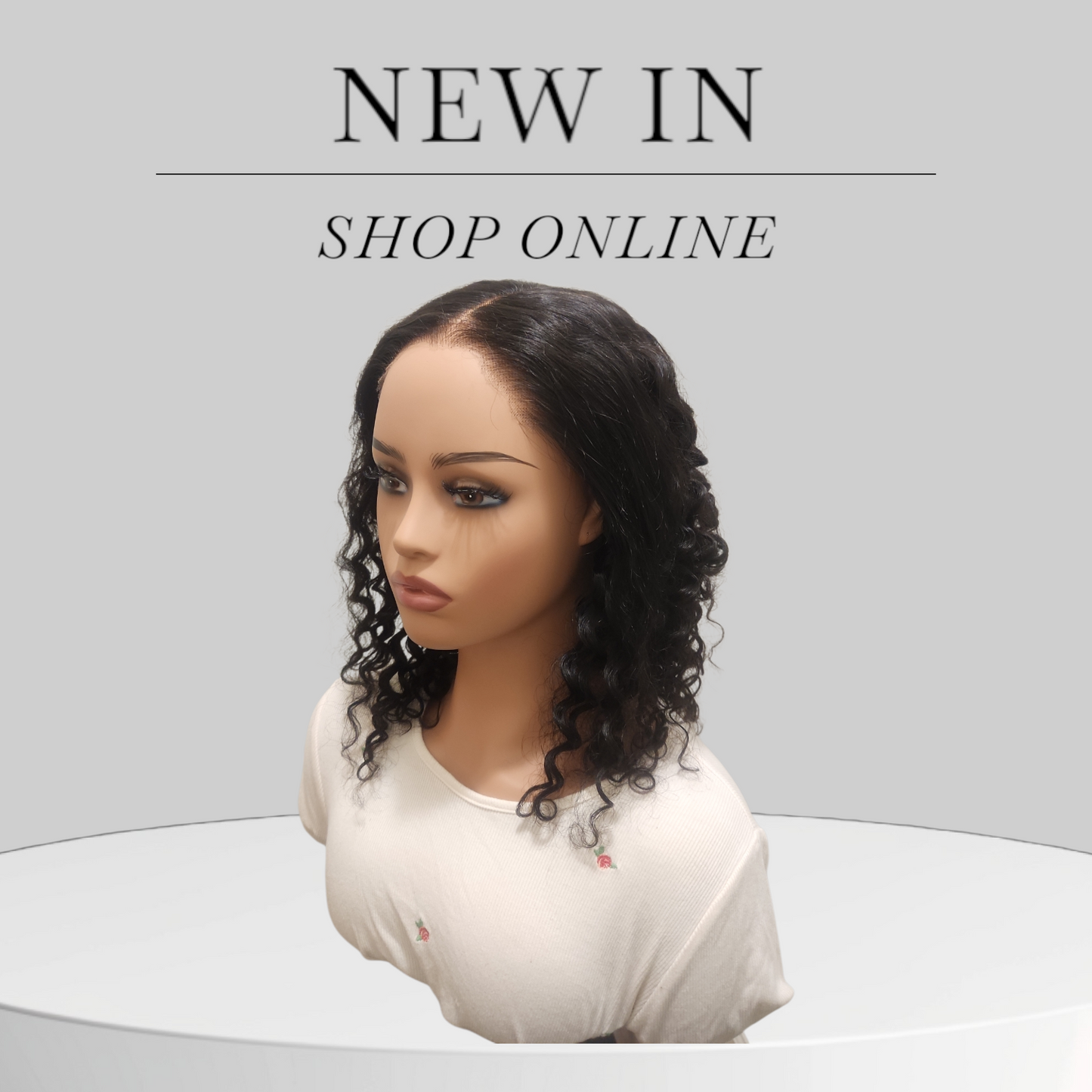 Mannequin head with a wig and text 'NEW IN SHOP ONLINE' on a gray background