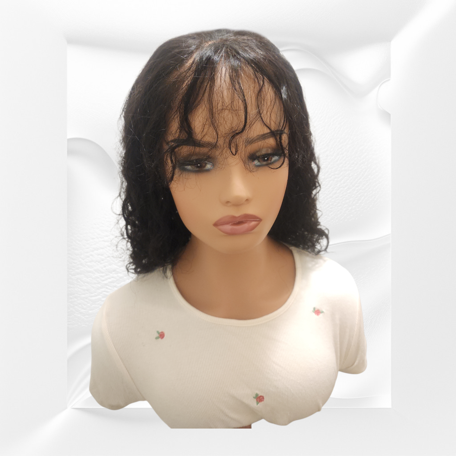 Mannequin head with a black wig on a white background