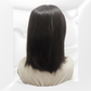 Black wig on a mannequin head against a white background